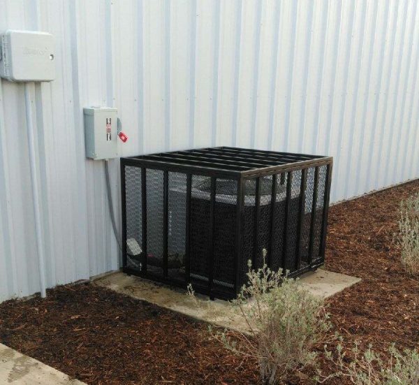 A durable black mesh enclosure surrounds outdoor utility equipment, combining security with a clean design, crafted by Inland Empire Fencing.