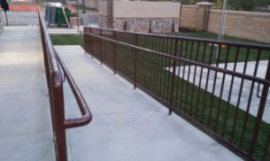A newly installed metal railing and fence system by Inland Empire Fencing ensures safety and adds a refined look to the commercial building's pathways.