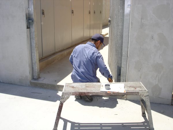 Inland Empire Fencing worker prepping materials for painting, demonstrating attention to detail in fencing enhancement services.