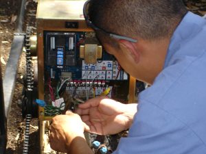 Close-up of an Inland Empire Fencing technician expertly wiring electrical components for a gate, showcasing technical proficiency in automated fencing systems.