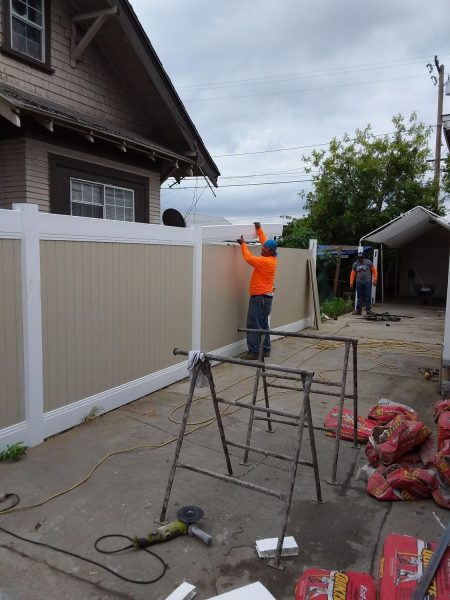 Inland Empire Fencing team installing a vinyl privacy fence, offering a low-maintenance and aesthetic solution for residential properties.