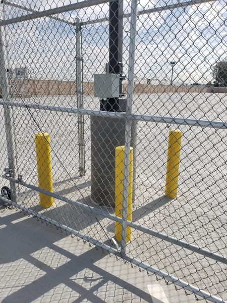 Chain-link fence with yellow vehicle barrier poles, demonstrating Inland Empire Fencing's integrated security measures for traffic control and pedestrian safety.