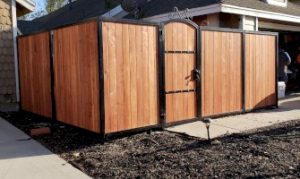 Wooden privacy fence enclosure with a flat top, showcasing durable construction for backyard security and privacy.