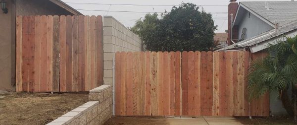 Decorative metal and wood fence combining security with elegance, featuring circular accents along the top rail.