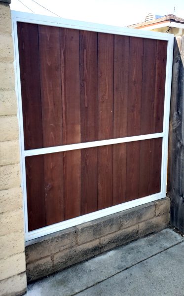 A sleek white-framed wood fence panel, demonstrating Inland Empire Fencing's custom design capabilities for elegant property boundaries.