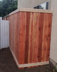 A wooden gate with diagonal slats and a sturdy metal frame, showcasing Inland Empire Fencing's unique designs for enhanced property aesthetics.