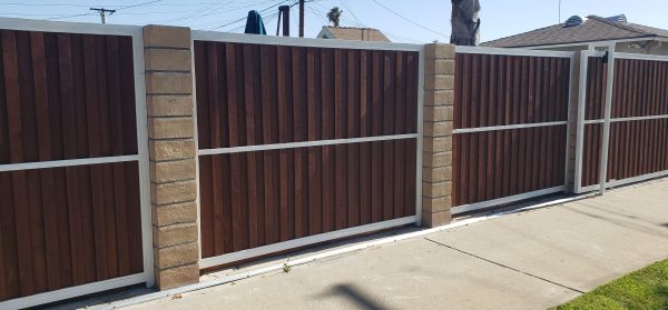 Double wooden fence gates set in a metal frame, representing Inland Empire Fencing's solutions for secure and accessible driveway entrances.