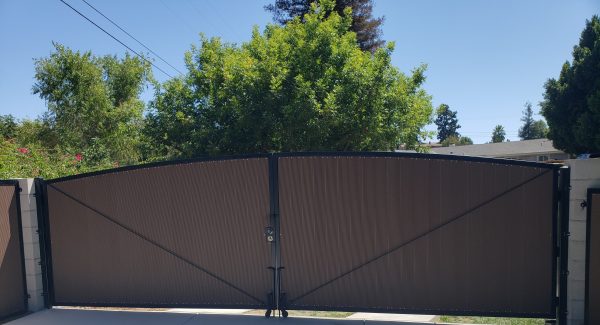 Large double-panel dark brown privacy gate for a driveway, offering a wide entrance and enhanced security, installed by Inland Empire Fencing specialists.