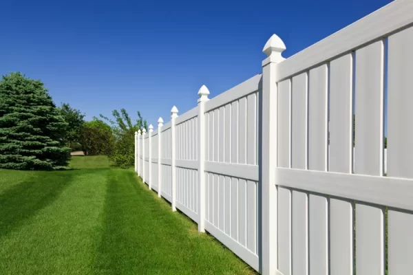 Spacious white double gate opening onto a bare driveway, projecting a clean and secure entrance point installed by Inland Empire Fencing.