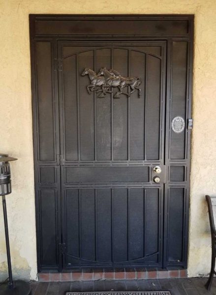 Elegant wrought iron security door with a detailed equestrian design, offering both protection and aesthetic appeal to a home entrance.